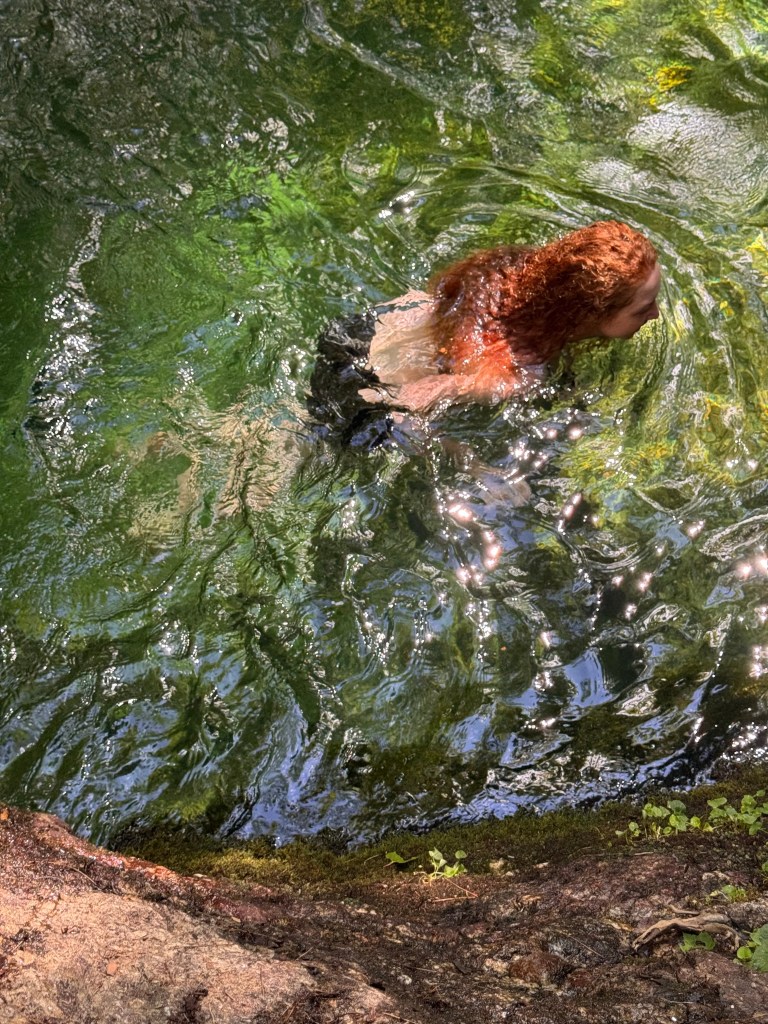 Image of green water and red curly hair
