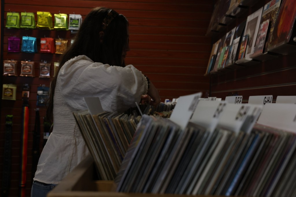 Image of girl flipping through records at a record store.