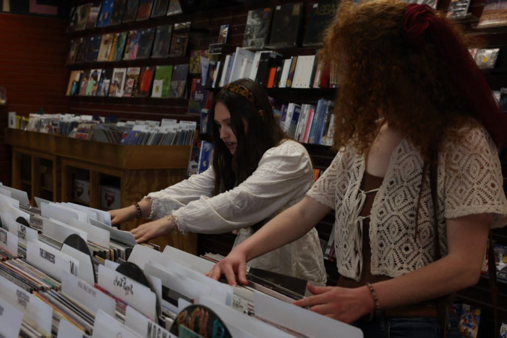 Photo of two girls flipping through records at a record store